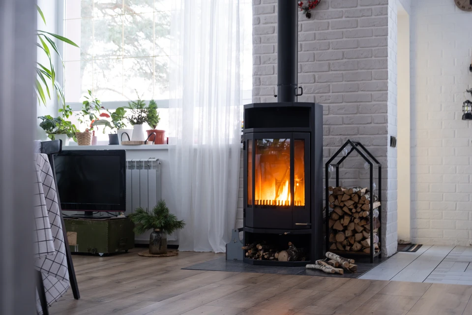 Intérieur moderne avec poêle à bois en fonctionnement, flammes visibles derrière la vitre