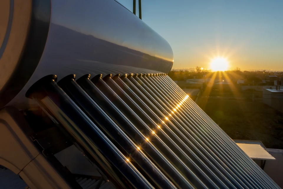 Chaudière thermique et panneaux solaires de chauffage source d'énergie alternative sur le toit de la maison sur fond de ciel bleu